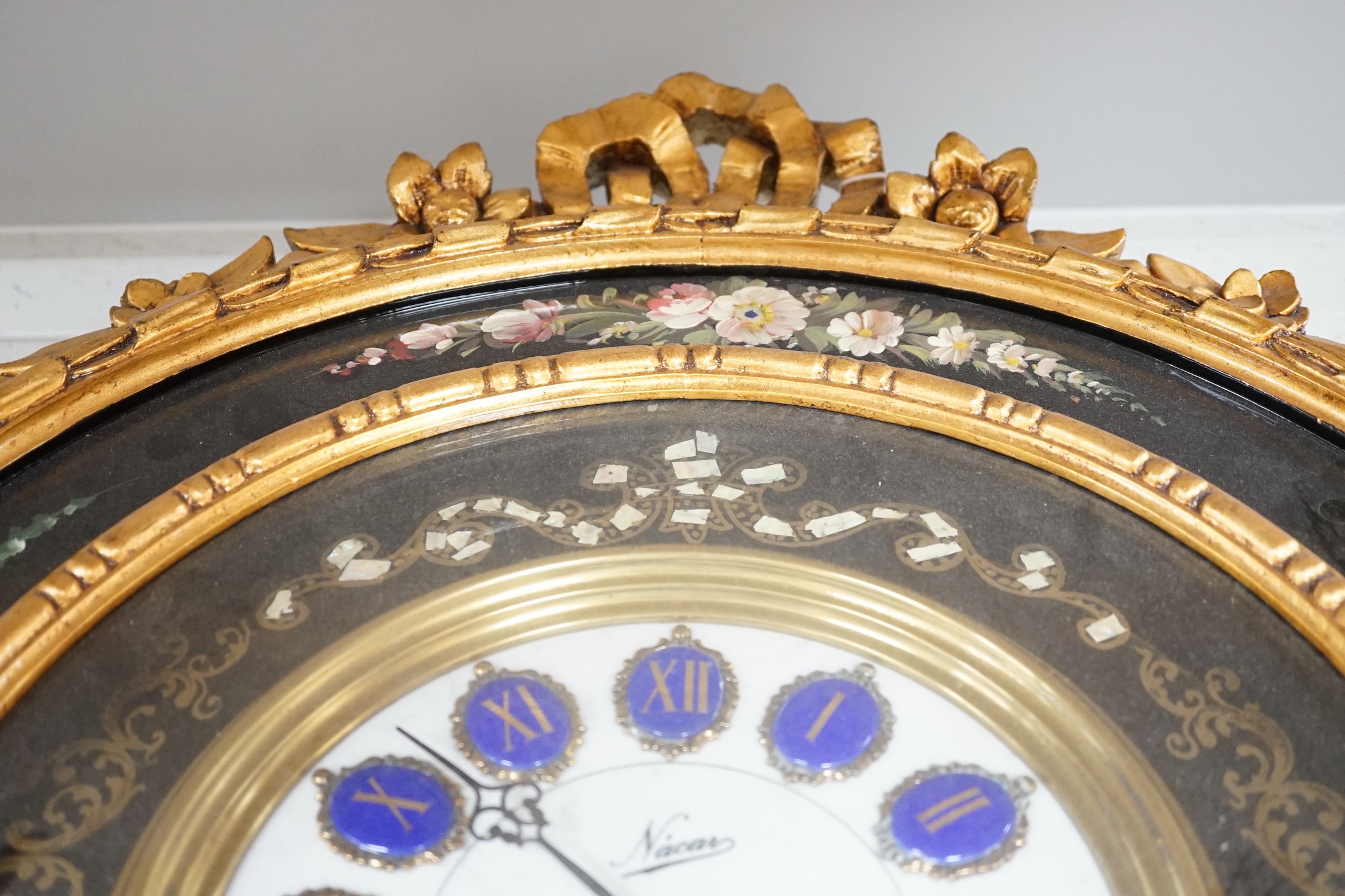 A floral painted clock, length 63cm, quartz movement